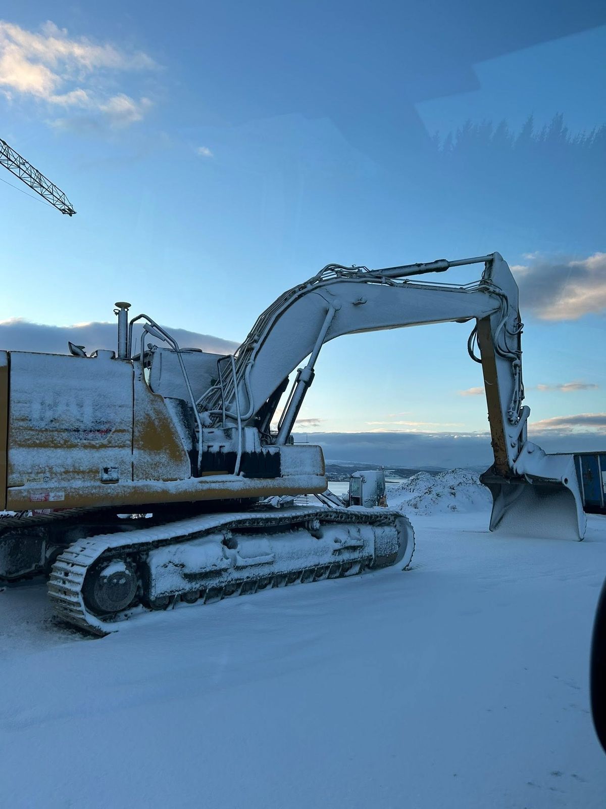 Snødekt gravemaskin på vinteroppdrag