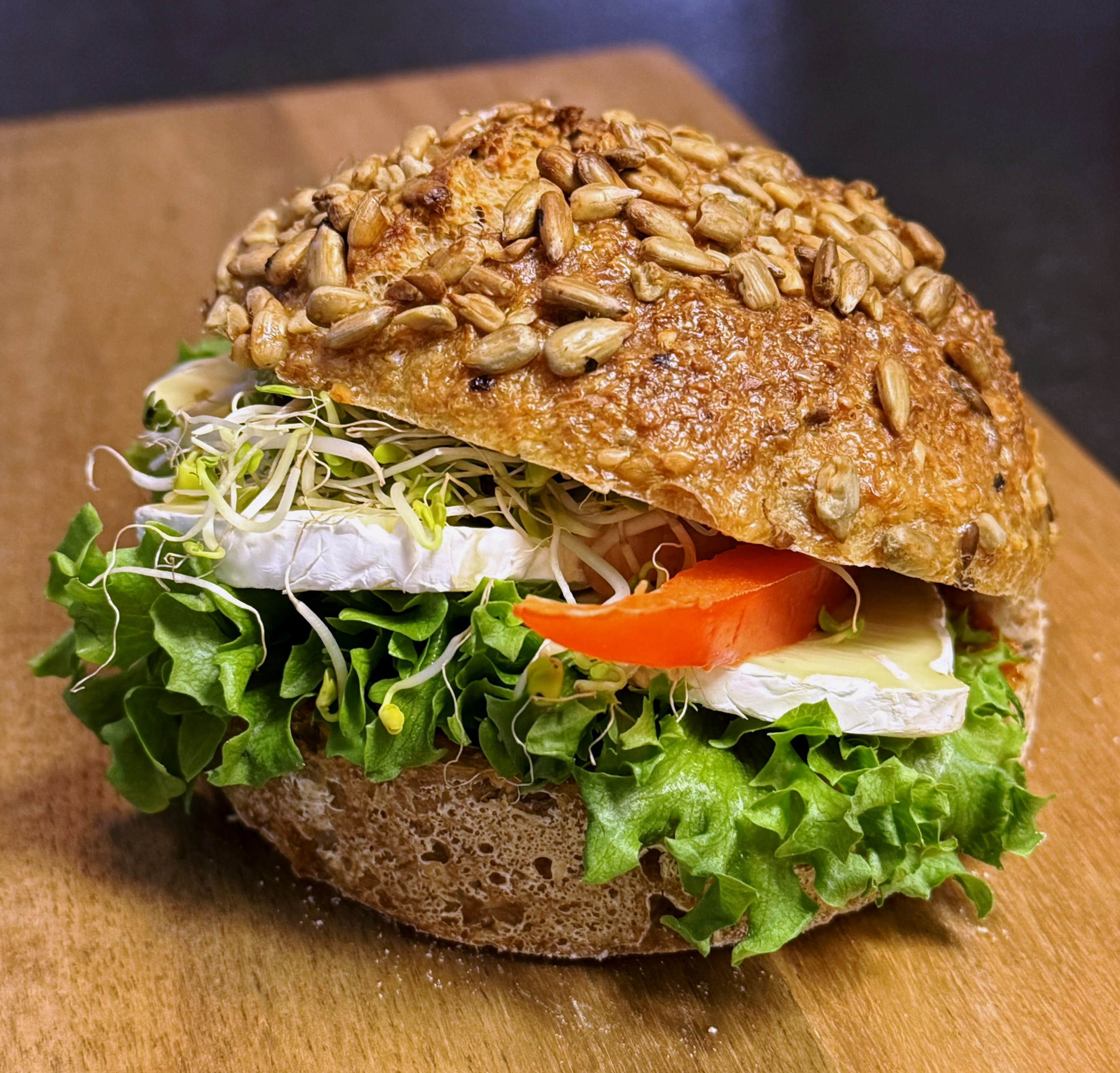 Rundstykke med brie, salat, tomat og spirer