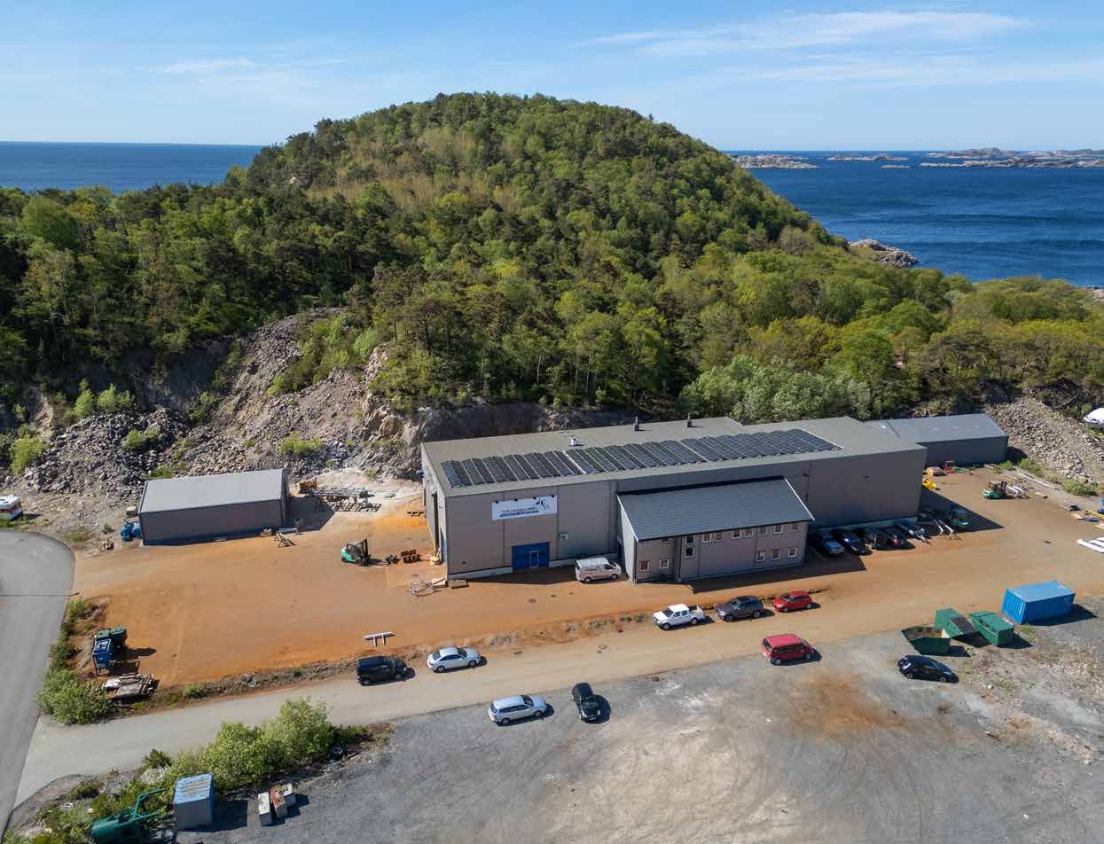 Dronefoto av anlegget til Tor Fasseland AS på Gismerøya i Mandal, med dypvannskai og solcellepaneler på taket