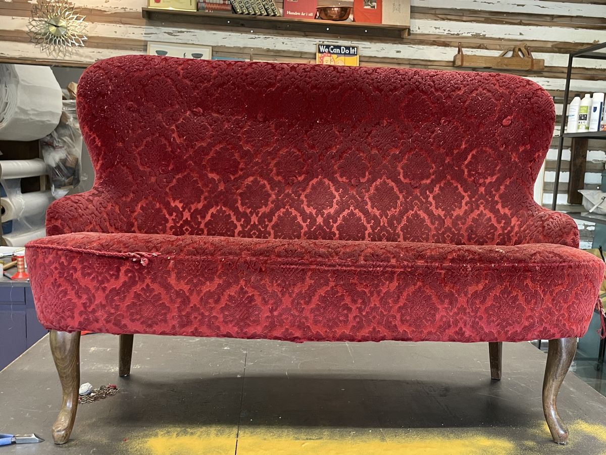 Sofa før omtrekking, i rødt mønstret stoff