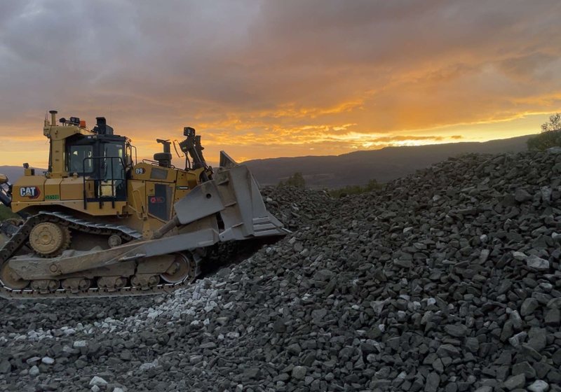 Dozer planerer veitrasé i solnedgang