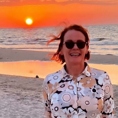 Elizabeth smiler på stranden i solnedgang