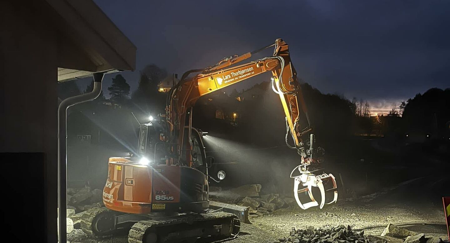 Gravemaskin fra Lars Thorbjørnsen Graving og Transport i arbeid på kveldstid