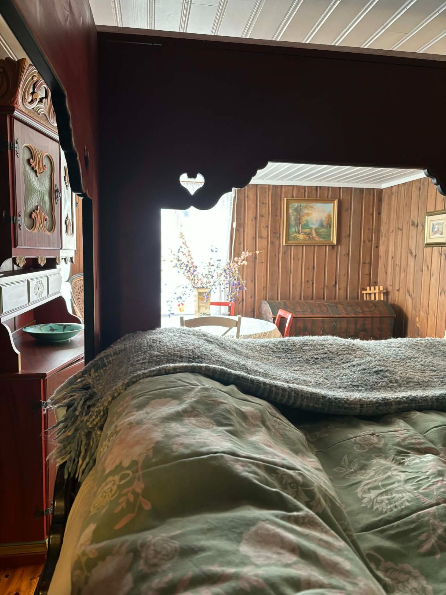 Eldhuset soverom – sett fra siden av den rødmalte himmelseng med rosemalt møblement