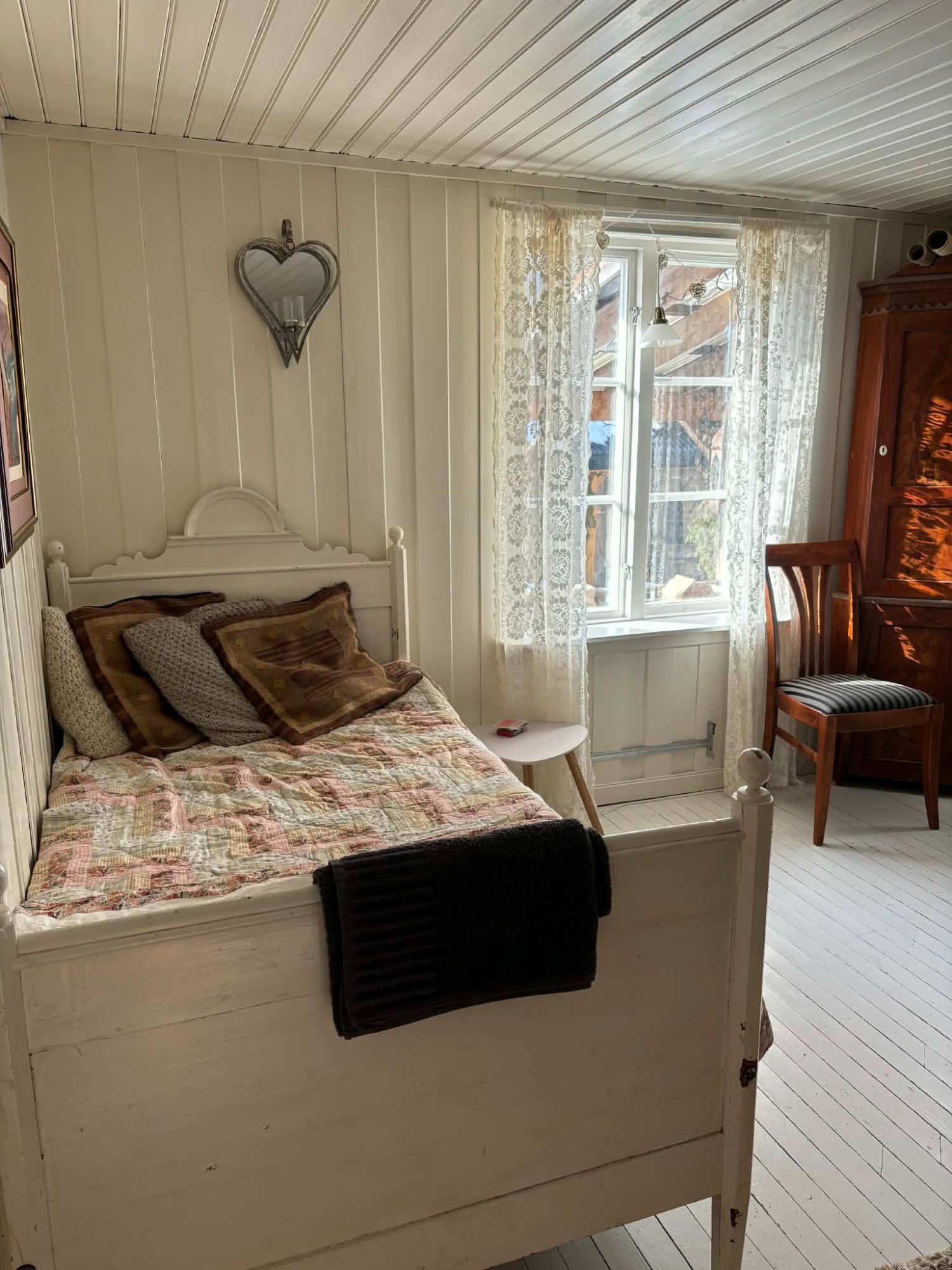 Eldhuset soverom 2 – lyst og romantisk rom med hvit antikk seng og blondegardin