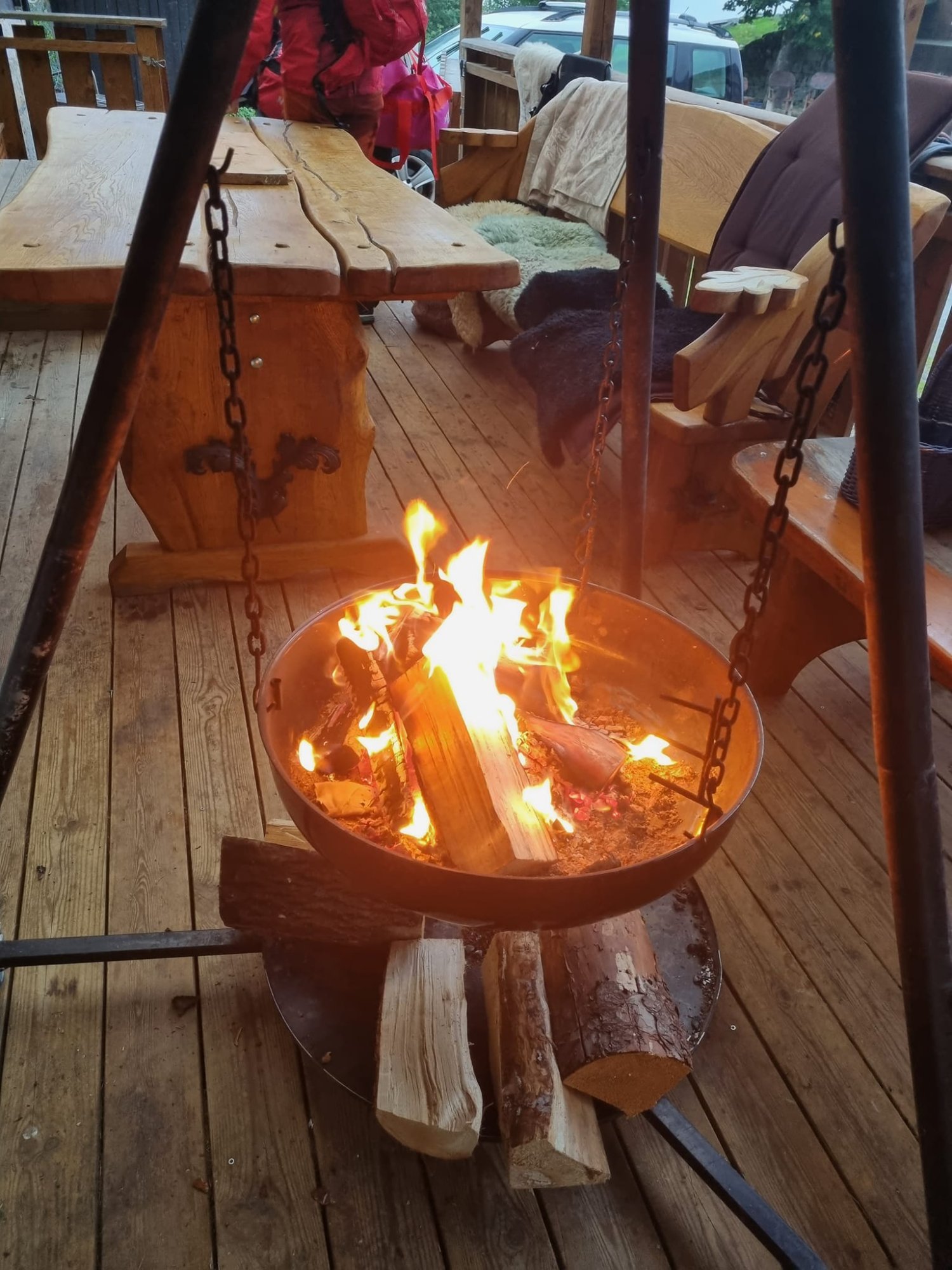 Eldhuset uteplass – bålpanne på terrassen med rustikke trebord og stoler