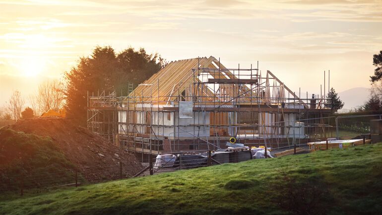 Hus under oppføring i solnedgang – nybygg fra Grimen Bygg