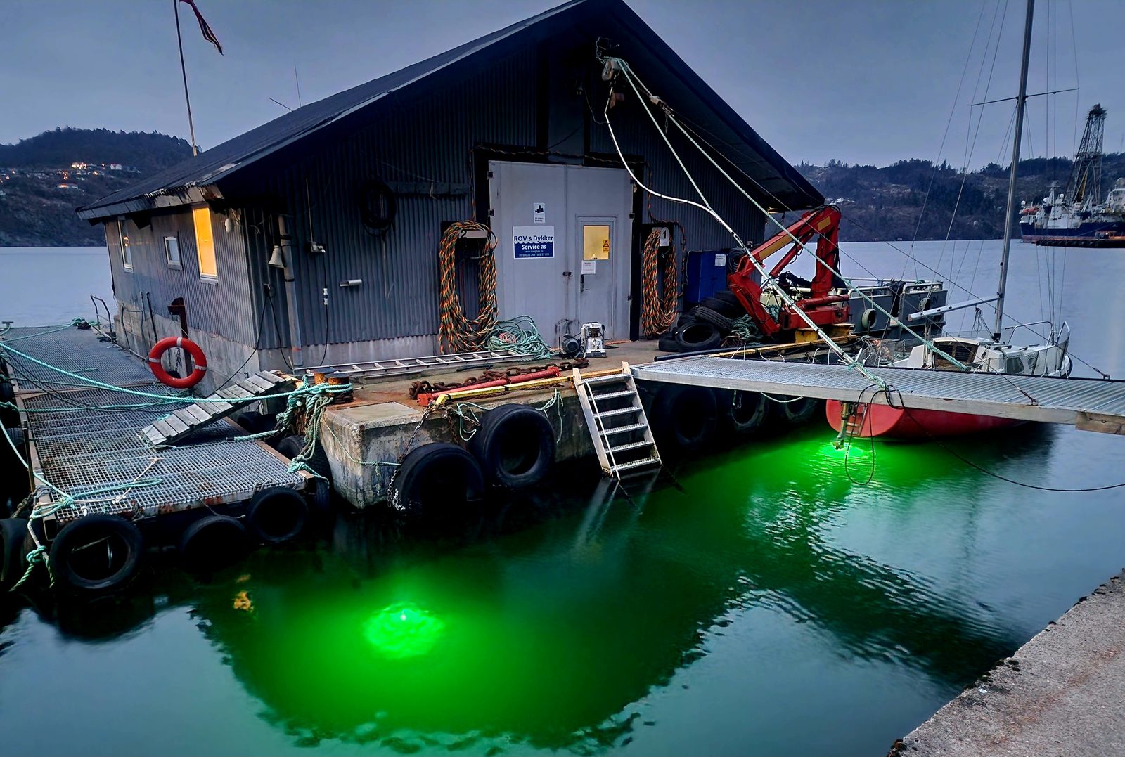 Lyngdal Sjøbase – den flytende basen i Rosfjorden opplyst en kveld