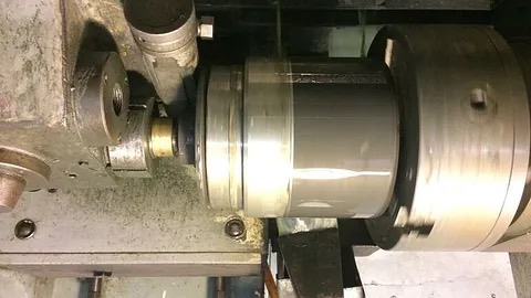 Hardbelegging og termisk sprøyting av maskindel