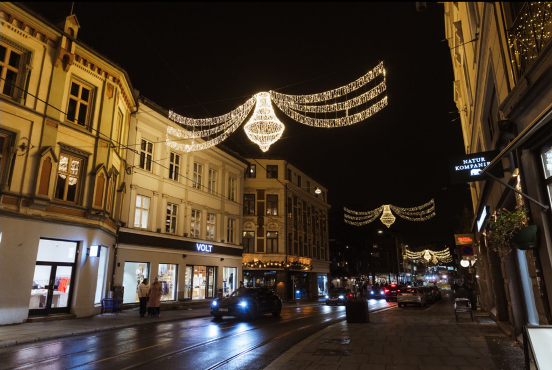 Julebelysning med lysekroner over gaten om kvelden