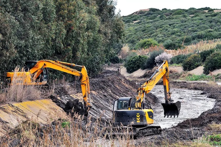 To gravemaskiner som graver ut og renser opp en kanal