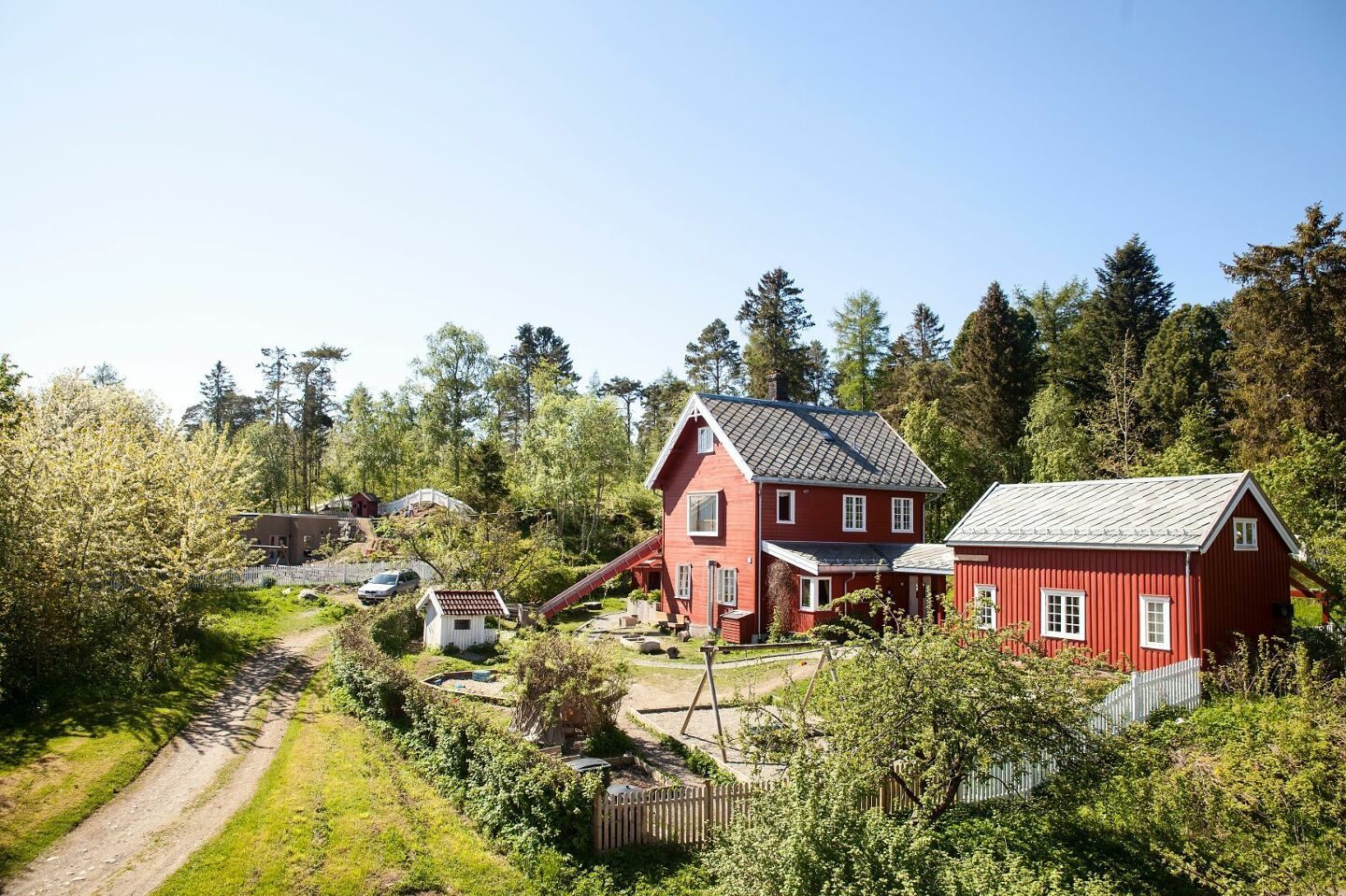 Steinerbarnehagen Rotnissen sett ovenfra en sommerdag, med de røde husene, hagen og lekeplassen