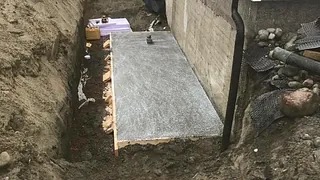 Nystøpt betongplate inntil en grunnmur
