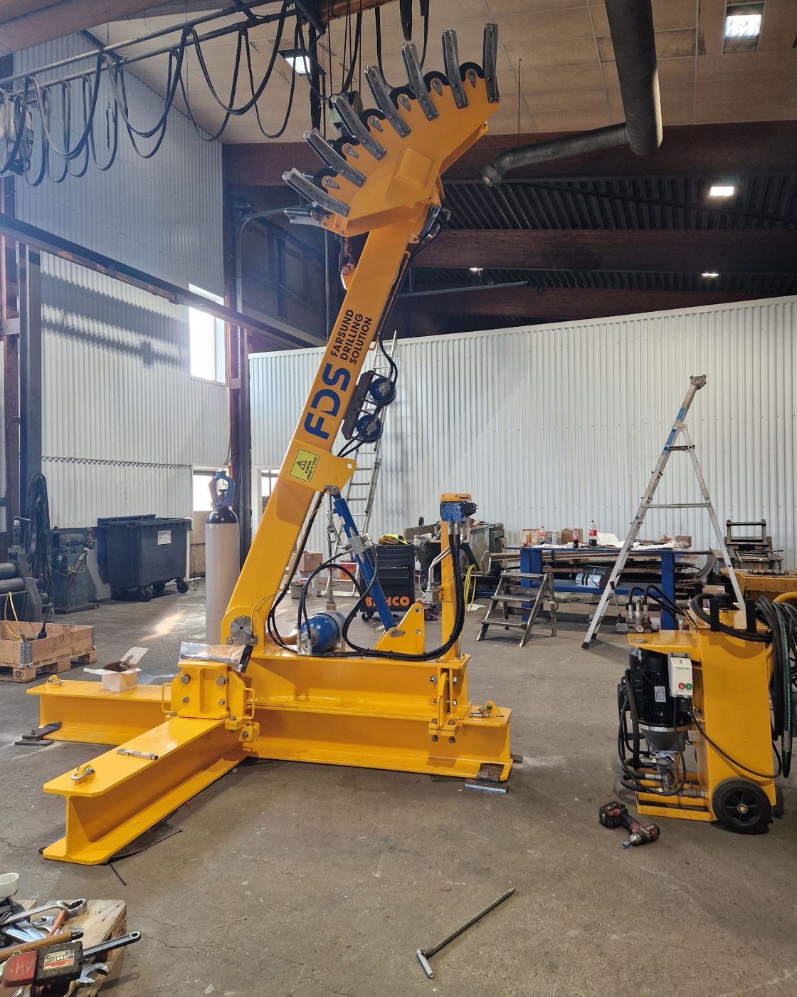 Gult hydraulisk utstyr med Farsund Drilling Solution-logo