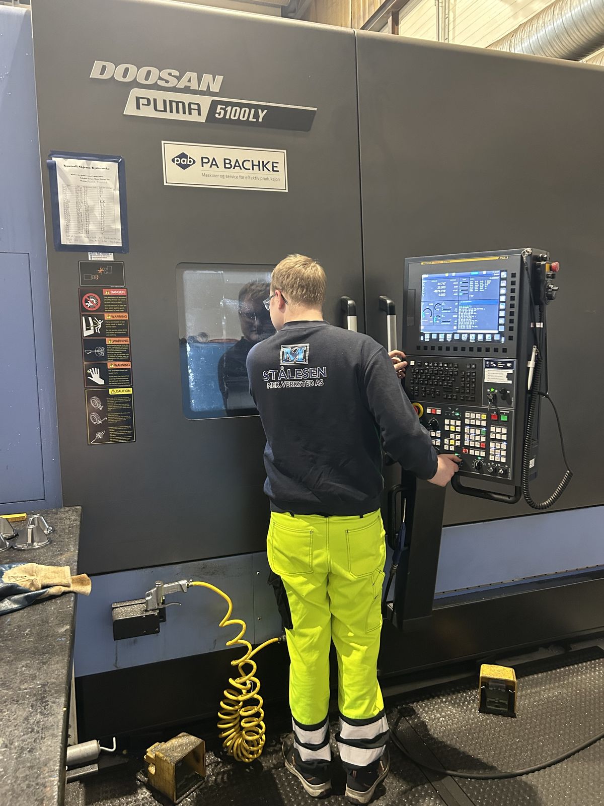 Ansatt betjener Doosan Puma CNC-dreiebenk