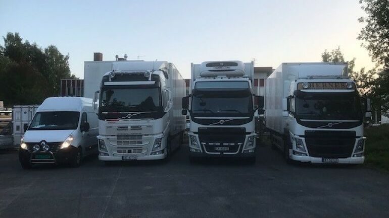 Hernes Transports lastebiler og varebil parkert side om side