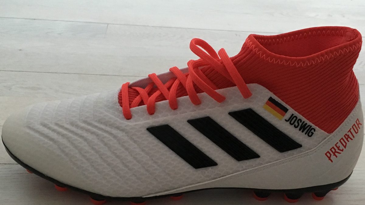 Hvite Adidas Predator-fotballsko med svarte striper og rød strikkekrage