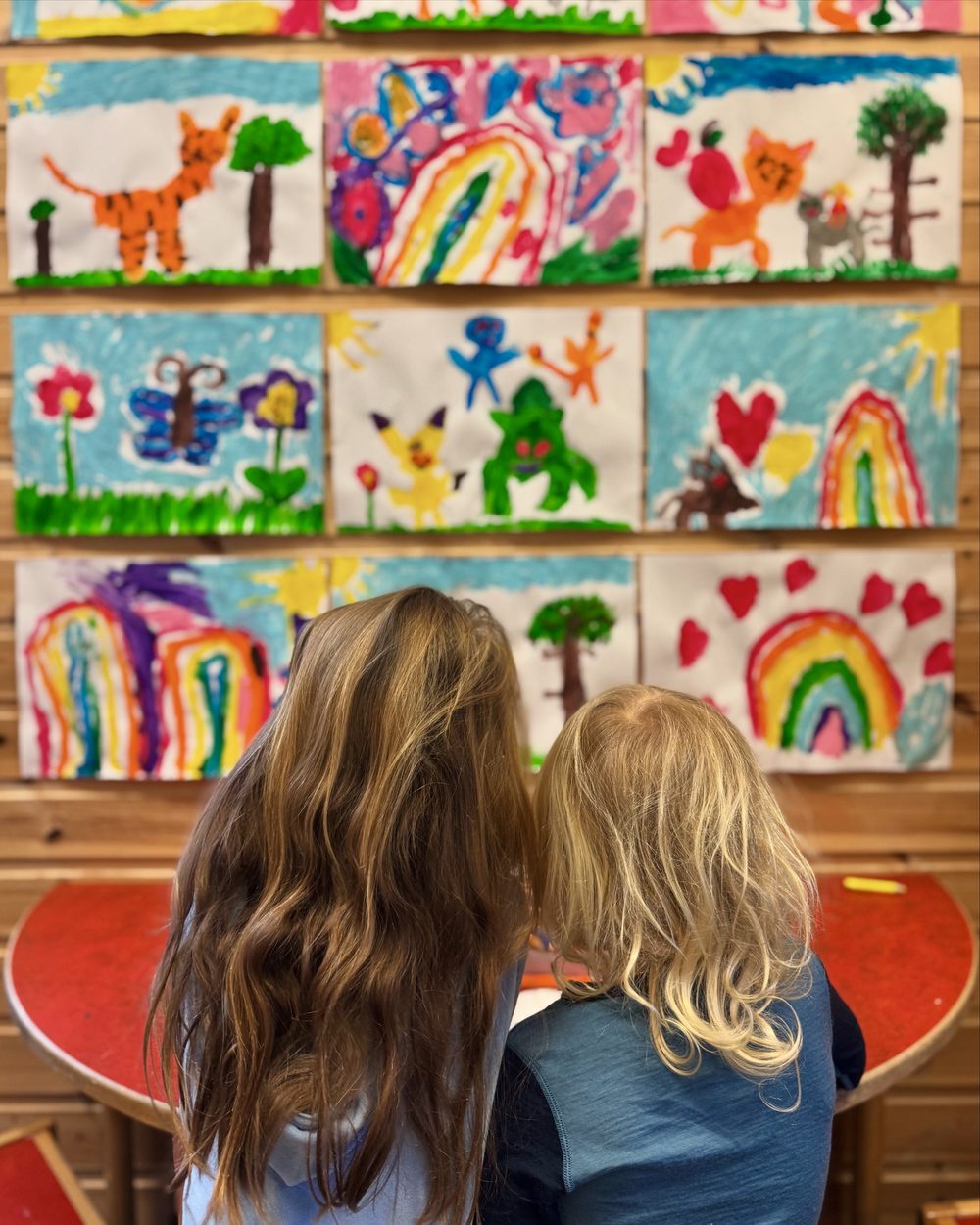 To jenter beundrer tegninger på veggen