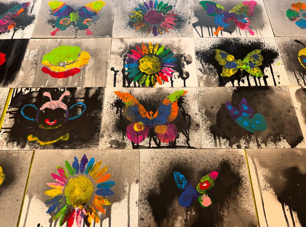 Barnas fargerike trykk-kunst utstilt på rekke