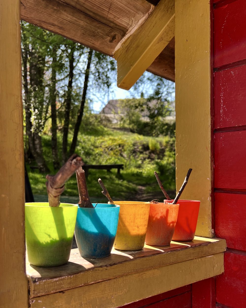 Fargerike kopper på vindusbrett i lekehuset