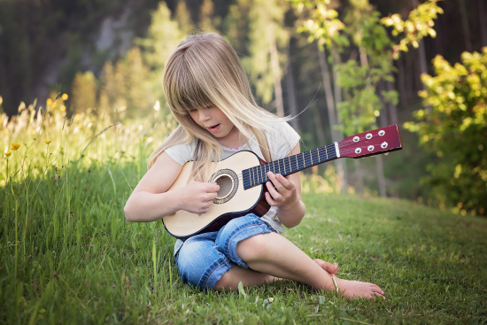 Et barn som øver på en gitar