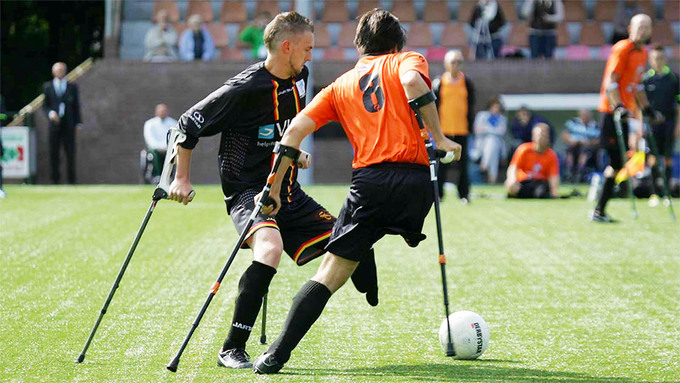 To menn spiller fotball. Begge har ett ben og bruker krykker i spillet.