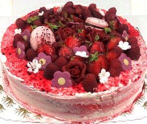 Kremkake pyntet med bær, marsipanpynt og makroner