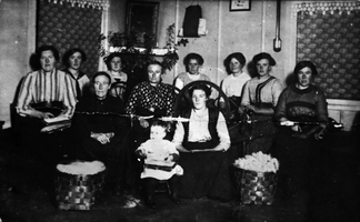 REF-0018   Gunnes,Stamnan, ca 1912.
Misjonsforening med karding og spinning.
F.v. Dortea Gunnes, Anne Gunnes, Ingeborg Gunnes, Randi Stavne, Ingeborg Gunnes(Nørgard), Eline Langklopp, Mette Gunnes, Oline Lien, Johanna Hoel, Mali Vold. Barnet er Ingeborg Gunnes.