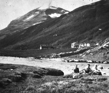 REF-0276 Søstuggusetra og Bruholtsetra i Svartådalen ca 1920
Bekken er Svartåa og i bakgrunnen
er Trollhetta. T.v.: sit 0lina Lundaløkk, som var på Søstuggusætra, og to ukjende turistar.
