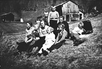 REF-0306 Krovoll Herrem Voll Rennebu ca 1934 Avslapping i graset, Kalvhåggån ved Krovoll - med sveivegrammafon.
F.v.: Gunda Uv, Gjertrud A. Krovold, 0la Holiløkk, Olga Krovold, Marit Krovold Gangås, Arne Brattbakk, Hans Brattbakk, Arne Hagen, Gjertrud Bakk (Vold) og Jon 0. Krovold (som sit ved gramrnafonen).