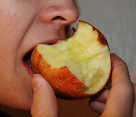En person biter i et eple