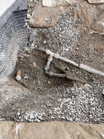 Vannlekkasjen oppdaget - befinner seg et sted på slangen i røret mellom husvegg og tennisbane