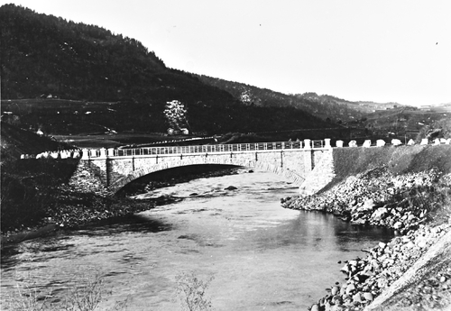 REF-0281  Nye Mærk bru, bygd 1899, sett fra sør.
Gardane er f.v.: Brustuggu (husnannsplass), Lundaiøkkja og Lundagjerdet (husmannsplass) - flytta til Egga oppå Jåren. Åsgrenda bak til
høgre.
