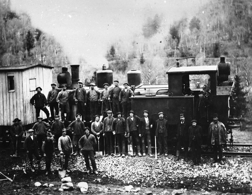 REF-0259 Damplokomotiv ved Valløkkja, Nordskogen med anleggsarbeidere. Lokomotivet ble brukt til å frakte pukk frå pukkverket ved Valløkkja.
1.r: nr 3 Nils Illøkken, nr 4 Ola Sletten
2.r. nr 4 Per Buum
3.r. nr 2 Ola Buum, nr 4 Jens O. Buum, nr 5 Erik Illøkken