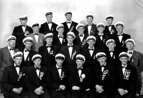 REF-0765 1956. Rennebu Mannskor. 1.rfv:Mikkel Fjellstad, Einar Rise, Jon Holiløkk, Per Holiløkk, Torgeir Haugen, Anders Stavnebrekk. 2.rfv:Ola Holiløkk, Joar Krovoll, Per P. Stavne, Jens O. Flå, Steinar Kvam, Rolv Gunnes, ?. 3.rfv:Einar Hoel, Magne Kvam, Arne Hårstad, Sivert T. Hoel, Erik Uvsløkk. 4.rfv:Ingebrigt O. Bakk, Ola J. Gunnes, Lars Skjerve, Gunnbjørn Hårstad, Jon O. Bakk.