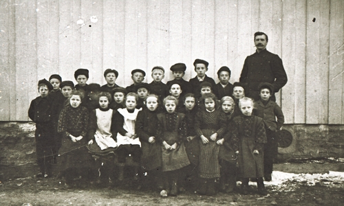 REF-0396 Voll ca 1913.
Skoleklasse ved gammelskolen på Voll med lærar Lars Mathias Hol.