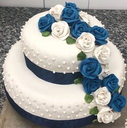 2 etg kake med standard roser, silkebånd og diamantmønter.