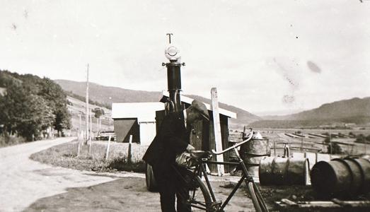 REF-0445  1940-åra.
Ved bensinpumpa på Samlaget på Stamnan. Anders I. Bakk står og gjer seg klar for heimturen.