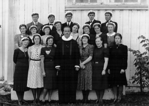 REF-0773 Ved Rennebu Kirke. Ca 1943. Rennebu Misjonskor. 1.r:Klara (Sæther) Voll, Gjertrud Sugustad, Olga Sandvei, Arne Sandvei, Marit Grendal (dirigent), Ragna Myren, Gjertrud (Voll) Bakk. 2.r:Ragnhild Voll Skjerve, Birgitte Rise, Johanna Fjelle, Olga Krovoll, Mali Meslo, Gerda (Bakken) Voll, Inga Voll, Kari Meslo. 3.r: Ingvar Lånke, Olav Voll, Sverre Voll, Jon Voll, Ingebrigt Voll.