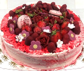 Kremkake pyntet med bær, marsipanblomster og makroner