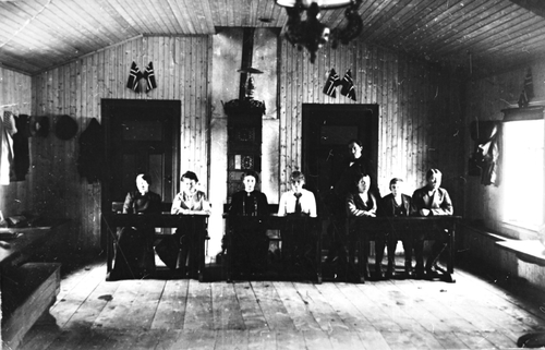REF-0167 Fridheim, Innset Rennebu ca 1915 Fortsettelses-skole i Fridheim. F.v: Margit Holthe, Eline Nygård, Kristine Paulsmo, Anbjørg Granli(g. Lien), Hans Austberg, Johan 0lsbakk og Esten Tørset. Bak: Lærar Jonas Berge..