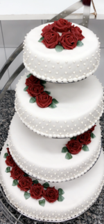 4 etg kake pyntet med håndlagde røde marsipanroser. Diamantmønster og perler på sidene.
