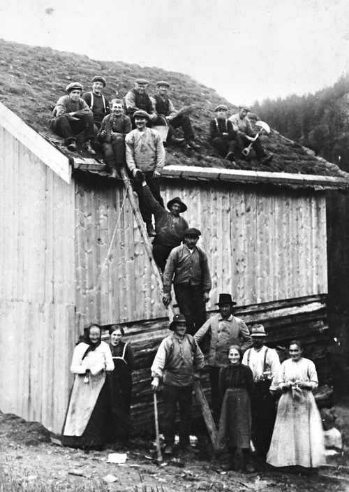 REF-0506 Søstuggu Flå, Stamnan 1916. Taktekking. På marka: Mali Søstuggun, Mali E. Flå, Ola Flaa, Gunhild Flå, Even Flå, Johanna Flå, Mikkel Kjønnum. Opp stigen: Johan T. Uv, John S. Flå, Ola J. Flå. På taket fv: Steinar E. Flå, Rasmus Flå, Martin Flå, John P. Flå, Anders Stavnebrekk, Tore Hoel, John Krokbekk.